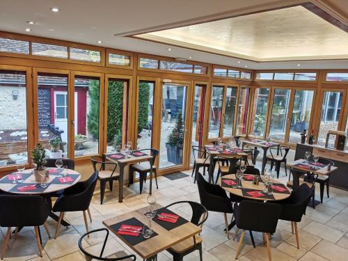 a restaurant with tables and chairs and windows at O'GB La Rennaissance in Chenonceaux