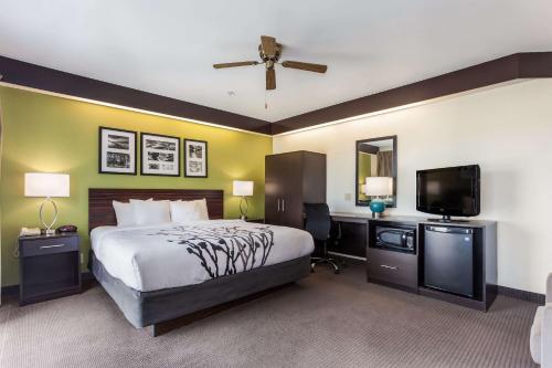a bedroom with a bed and a flat screen tv at Sleep Inn Little River - North Myrtle Beach in Little River
