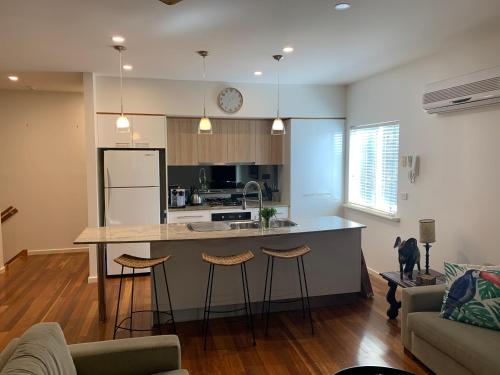 a kitchen with a counter and stools in a room at Bella vista in Maslin Beach