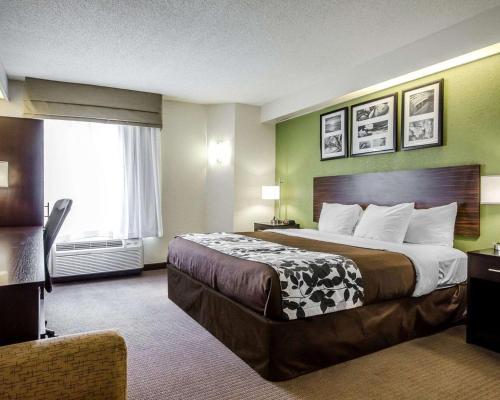 a hotel room with a large bed and a window at Sleep Inn Louisville Airport & Expo in Louisville