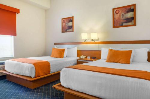 Postel nebo postele na pokoji v ubytování Greenwood Hotel Torreón