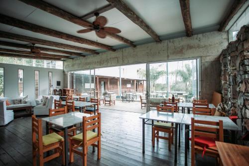 un restaurante con mesas y sillas y un ventilador de techo en Altos de la Serena Apart Hotel, en La Paloma