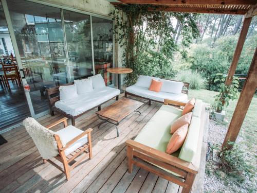 un porche cubierto con muebles y mesa en Altos de la Serena Apart Hotel, en La Paloma