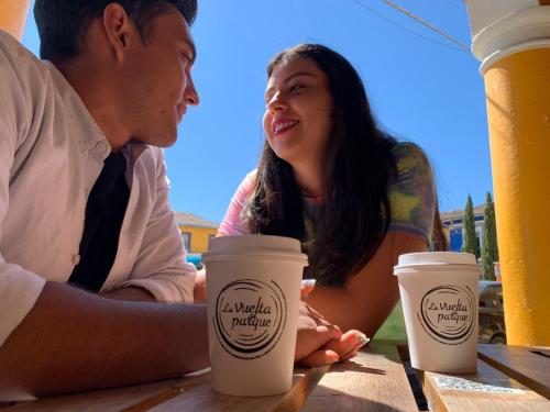 a man and a woman sitting at a table with coffee cups at Hotel Santa Fe in Tlatlauquitepec