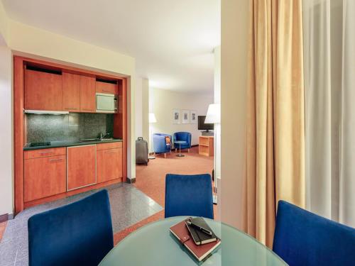 a room with a table and chairs and a kitchen at Mercure Hotel & Residenz Berlin Checkpoint Charlie in Berlin