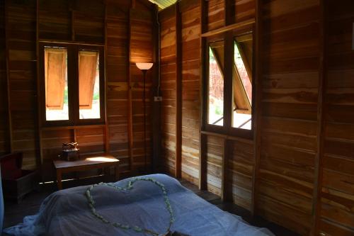 a bedroom with a bed in a room with windows at Homebar in Ko Chang