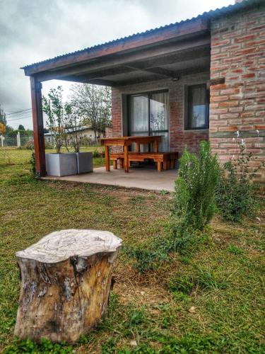 a house with a tree stump in the yard at Atardecer Serrano in Villa General Belgrano