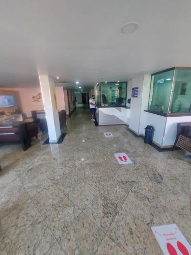 um lobby vazio de um edifício com uma pessoa de pé nele em loft Prainha em Arraial do Cabo