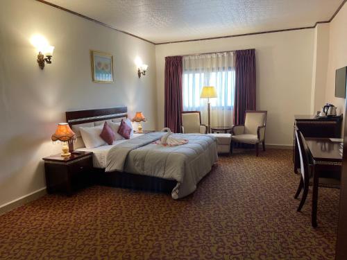 a hotel room with a bed and a desk at Boulevard Palace Hotel in Monrovia