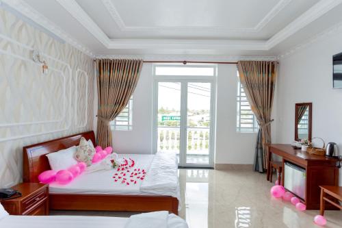 um quarto com uma cama com balões cor-de-rosa em Lee Hotel em Can Tho
