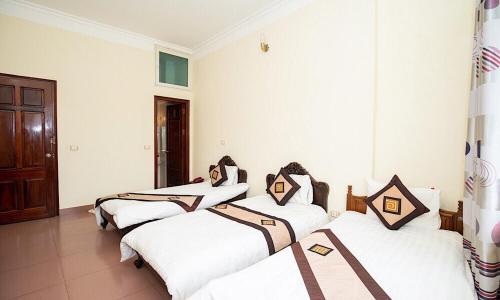 three beds in a room with white walls at Ho Sen Xanh Hotel in Hanoi