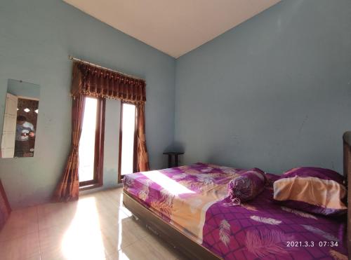 a bedroom with a bed and a window at Puncak Pinus and Pool in Batu