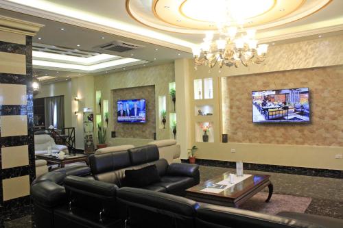 a living room with a couch and a tv at Boulevard Palace Hotel in Monrovia