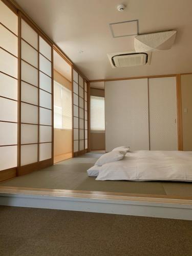 岡山的住宿－Oxio 飯店，卧室配有白色的床