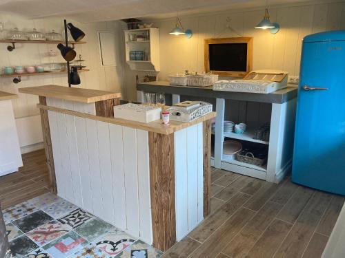 a kitchen with a counter and a blue refrigerator at Oleander Romantik Zimmer in Trausdorf