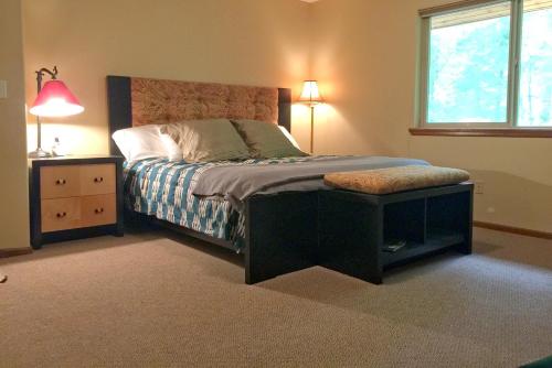 a bedroom with a bed with a night stand and a window at Snowline Cabin 29 - An Ultra Custom Family Vacation Home in Glacier