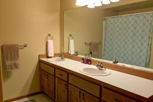 a bathroom with two sinks and a large mirror at Snowline Cabin 29 - An Ultra Custom Family Vacation Home in Glacier