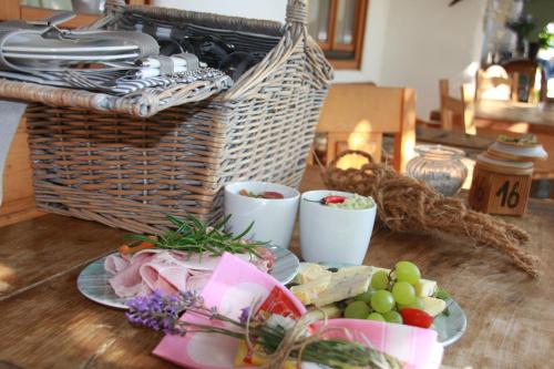 a table with plates of food and a basket of food at Oleander Romantik Zimmer in Trausdorf