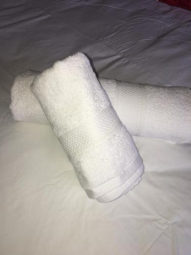 a white cast on a persons leg on a bed at Asante’s Guest House in Calcutta