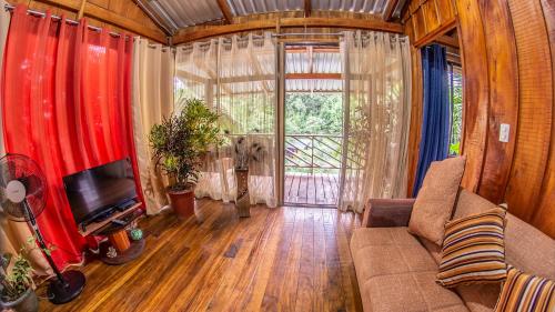 a living room with a couch and a tv at Cabañas del Lago in Fortuna