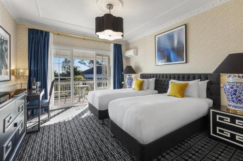 a hotel room with two beds and a balcony at voco® Kirkton Park Hunter Valley by IHG in Pokolbin