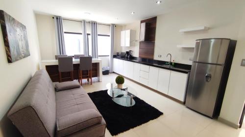 a living room with a couch and a kitchen at Condominios Costa Diamante in San Carlos