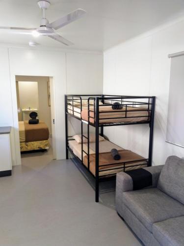 a living room with bunk beds and a couch at Oasis Tourist Park in Palmerston