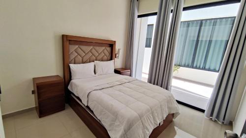 a bedroom with a bed and a large window at Condominios Costa Diamante in San Carlos