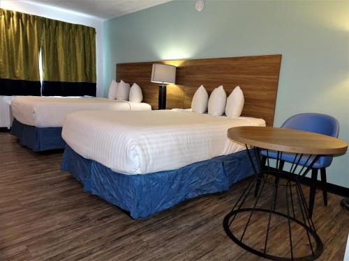 a hotel room with two beds and a table at Days Inn by Wyndham Lake Havasu in Lake Havasu City
