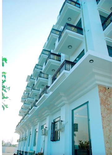 a white building with balconies on the side of it at khách Sạn Yên Châu in Chau Doc