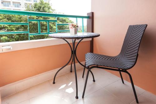 a table and chair in a room with a window at Vabua Asotel Bangkok in Bangkok