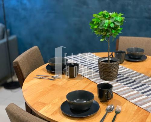 a wooden table with black bowls and a potted plant on it at Spacious Big Room, Designed & Quiet Family Home, Eclipse in Cyberjaya by Flexihome-MY in Cyberjaya