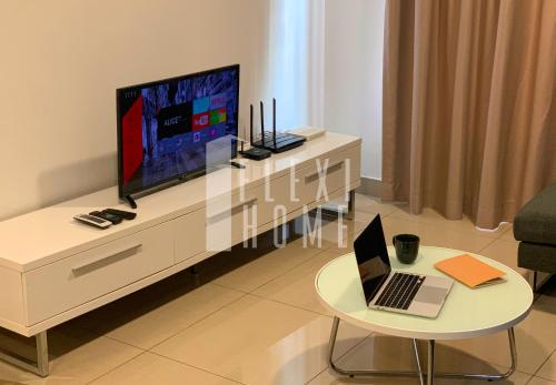 a living room with a television and a laptop on a table at Spacious Big Room, Designed & Quiet Family Home, Eclipse in Cyberjaya by Flexihome-MY in Cyberjaya