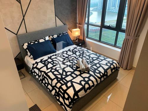 a bedroom with a bed with blue pillows and a window at Spacious Big Room, Designed & Quiet Family Home, Eclipse in Cyberjaya by Flexihome-MY in Cyberjaya