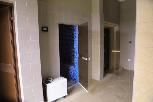 W łazience znajduje się prysznic z niebieskimi kafelkami. w obiekcie Haile Resort Adama w mieście Adama