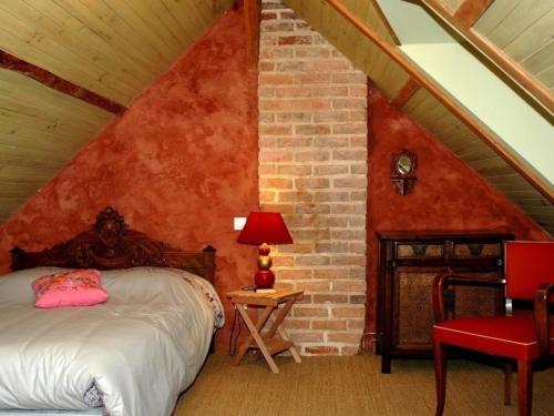 een slaapkamer met een bed en een bakstenen muur bij Gîte Fondettes, 3 pièces, 4 personnes - FR-1-381-380 in Fondettes