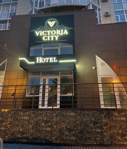 uma placa de hotel na lateral de um edifício em отель VICTORIA CITY em Achinsk