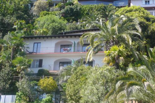 an apartment building in the midst of trees at Residenza Bettina BnB & Ferienwohnungen in Ronco s/Ascona - Porto Ronco