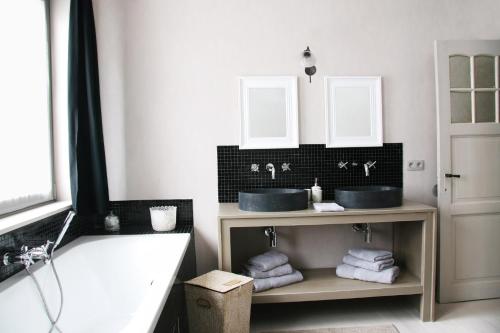 a bathroom with two sinks and a bath tub at ieperlee 23 Holiday Home in Ieper