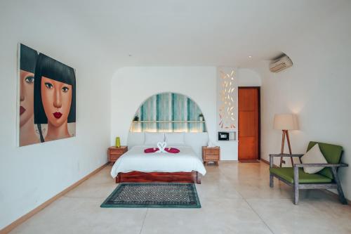 a bedroom with a bed and a large painting on the wall at Nazeki Villa in Uluwatu
