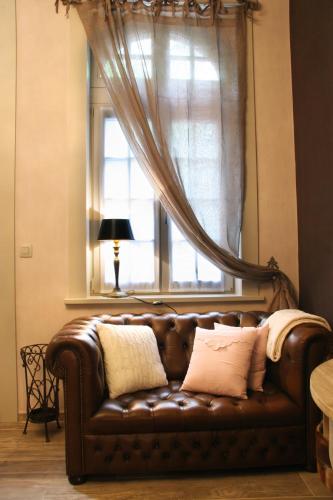 a brown leather couch sitting in front of a window at ieperlee 23 Holiday Home in Ieper