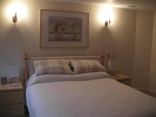 a bedroom with a bed with two lights on the wall at The Cavalier House B&B in Hastings