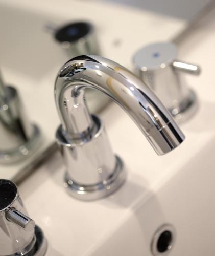 a bathroom sink with a silver faucet at Santika Premiere Dyandra Hotel & Convention - Medan in Medan