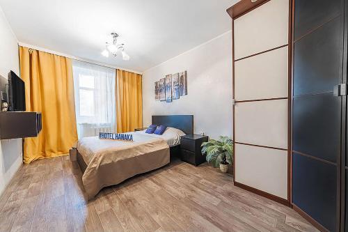 a bedroom with a bed and a tv in a room at Apartment Hanaka Zeleniy 83 in Moscow