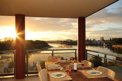 a table on a balcony with a view of a river at Spinnaker 201 in Forster