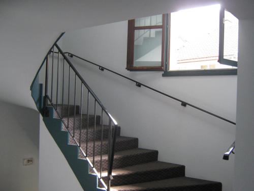 a staircase in a house with a window at Hôtel Le Lacuzon in Moirans-en-Montagne