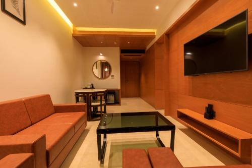 a living room with a couch and a tv at Lords Eco Inn Jamnagar - Apple Gate in Jamnagar