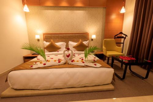 a bedroom with a bed with two pillows and a chair at Lords Eco Inn Jamnagar in Jamnagar