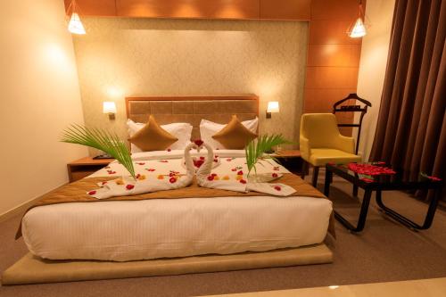 a bedroom with a bed with two pillows and a chair at Lords Eco Inn Jamnagar - Apple Gate in Jamnagar