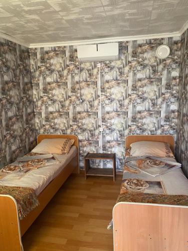 ソリ・イレツクにあるGuest House Chocolateの壁紙を用いた部屋のベッド2台